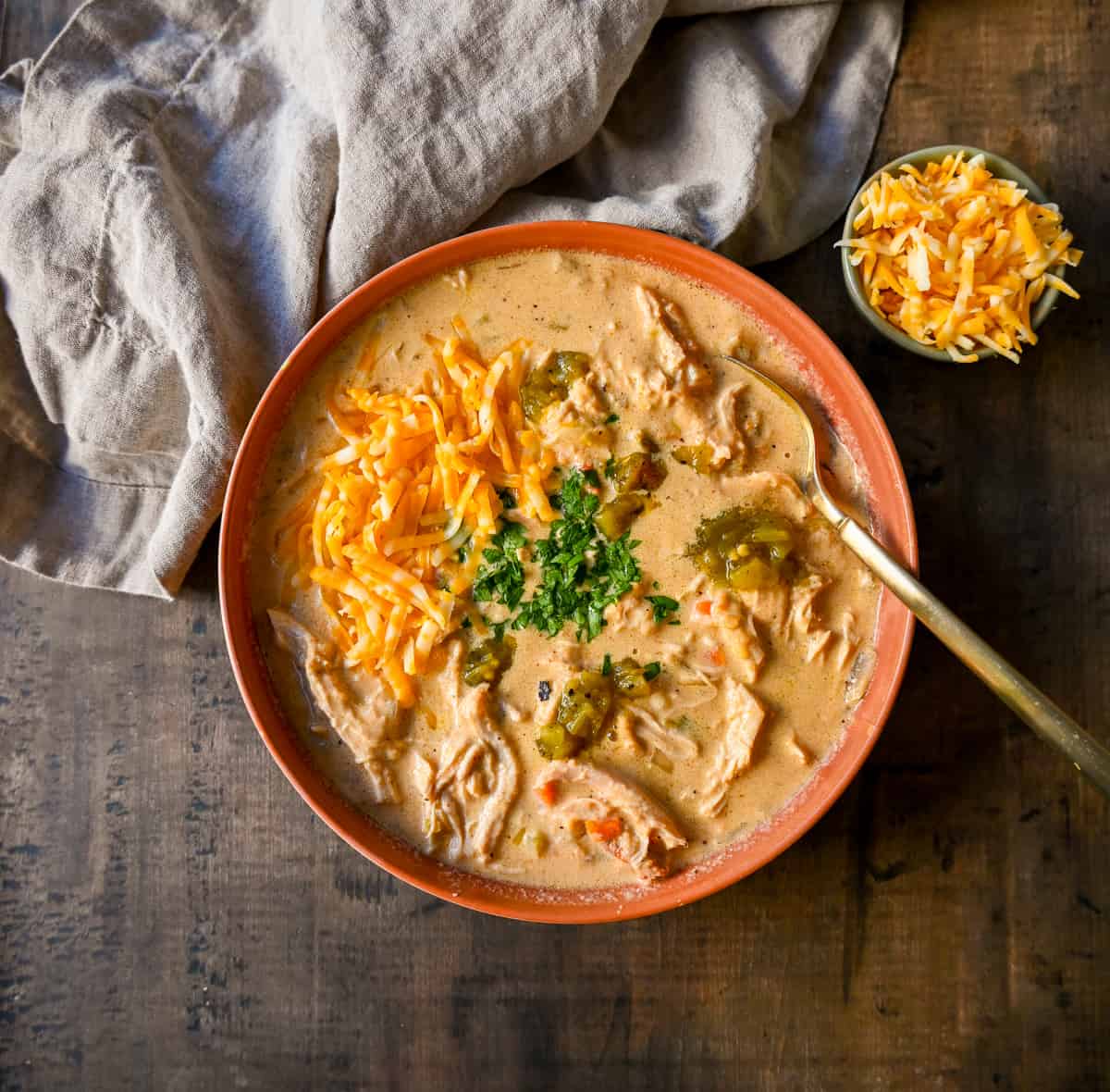 Rich, cheesy chicken queso soup made with three types of cheeses, tender chicken, green chiles, and spices—all the flavors of cheese queso but in a soup! The creamiest, most flavorful Chicken Cheese Soup.