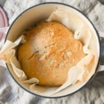 No Knead Overnight Crusty Bread Recipe. This No Knead Bread is baked in a dutch oven and is the perfect crusty french bread recipe. This makes a beautiful artisan loaf of bread and is so easy! The only ingredients you need are flour, water, salt, and yeast for the perfect overnight crusty bread.
