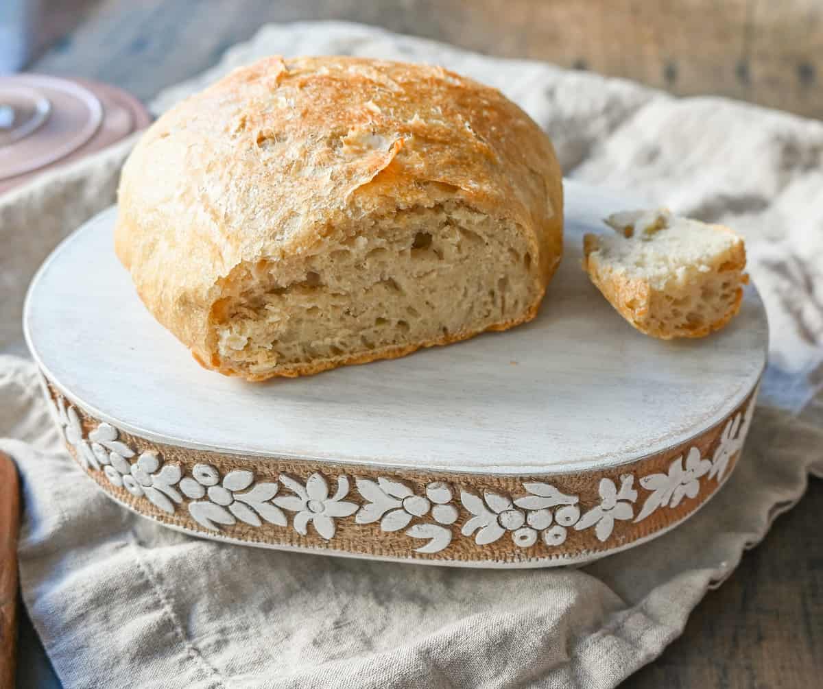 No Knead Overnight Crusty Bread Recipe. This No Knead Bread is baked in a dutch oven and is the perfect crusty french bread recipe. This makes a beautiful artisan loaf of bread and is so easy! The only ingredients you need are flour, water, salt, and yeast for the perfect overnight crusty bread.