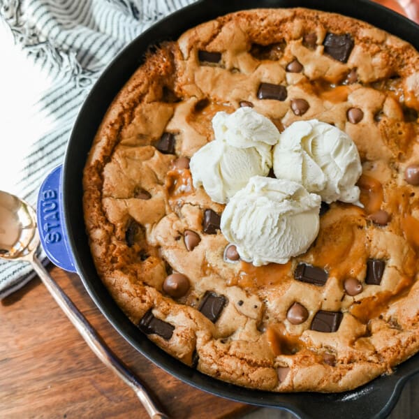 This salted caramel chocolate skillet cookie baked in a cast iron skillet and topped with vanilla ice cream has the perfect combination of sweet and salty caramel, and decadent chocolate in a perfectly buttery cookie.