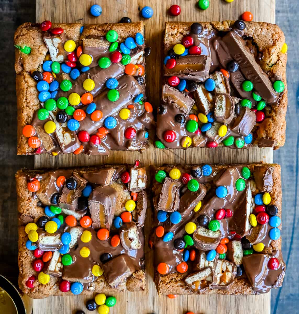 Candy Bar Cookie Bars. An ooey gooey cookie bar topped with an assortment of candy bars. The perfect candy bar blondie dessert to make with Halloween candy.