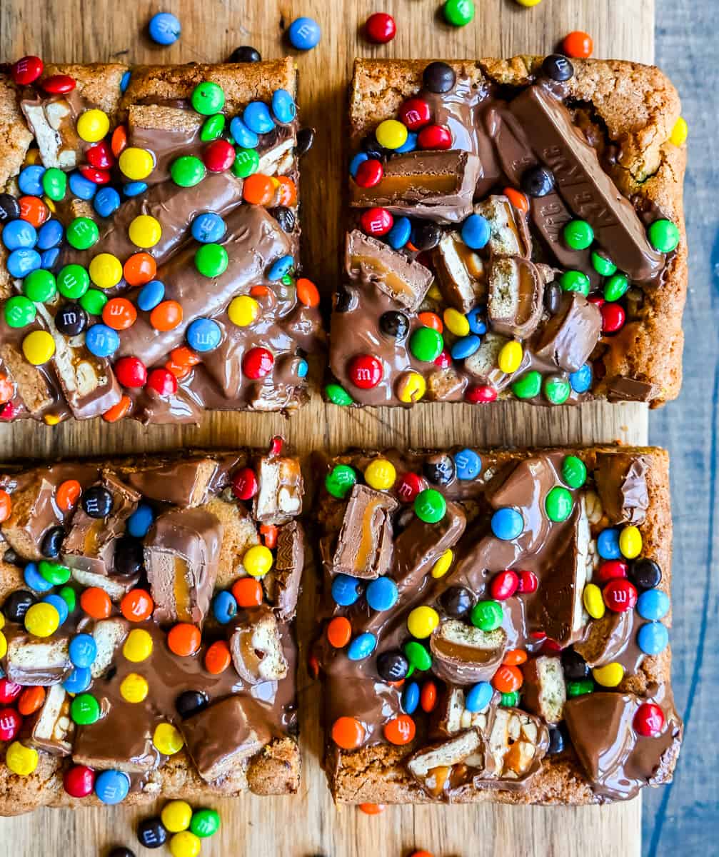 Candy Bar Cookie Bars. An ooey gooey cookie bar topped with an assortment of candy bars. The perfect candy bar blondie dessert to make with Halloween candy. 