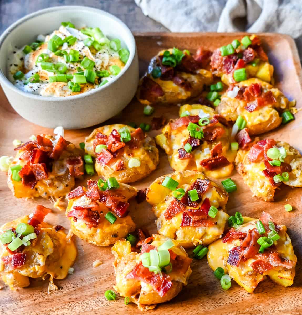 Loaded Bacon Cheddar Smashed Potatoes. These bacon cheddar loaded smashed potatoes start with crispy and buttery smashed potatoes topped with bacon, cheddar cheese, and green onions. These loaded smashed potatoes are the perfect side dish.