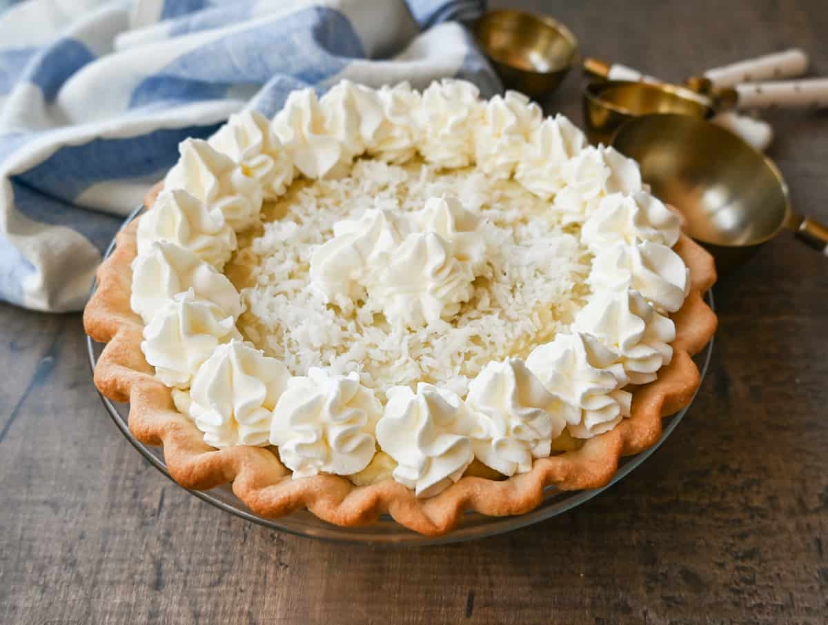 This Coconut Cream Pie is made with a homemade coconut custard filling in a buttery pie crust topped with fresh whipped cream and toasted coconut. This is the famous Dahlia Bakery's secret coconut cream pie recipe.