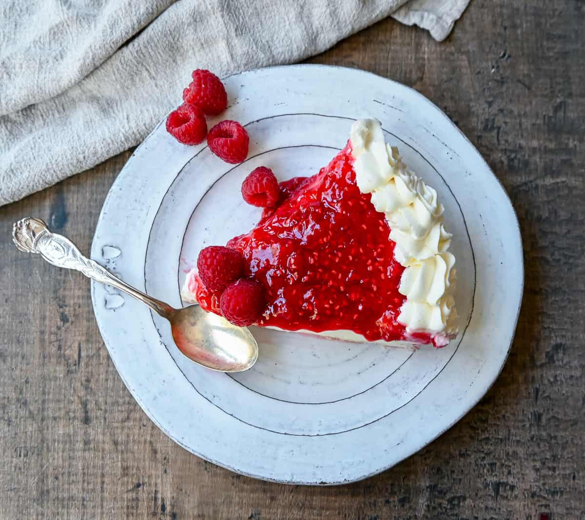 This Homemade Raspberry Cream Pie is made with a sweet luscious cream cheese filling and topped with a homemade raspberry sauce all in a homemade crust. This No-Bake Raspberry Cream Cheese Pie will become one of your absolute favorites!