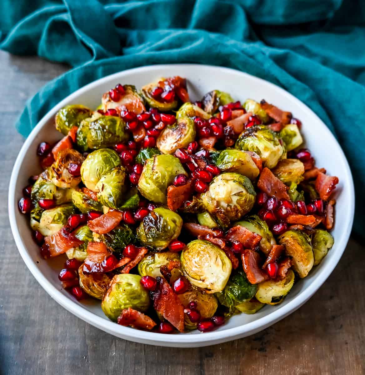 Roasted Brussels Sprouts with Bacon. These Roasted Brussels Sprouts are tossed in extra-virgin olive oil and spices and cooked until soft on the inside and crispy on the outside then drizzled with real maple syrup and served with crispy bacon and crunchy pomegranates. The perfect Fall and holiday side dish recipe.