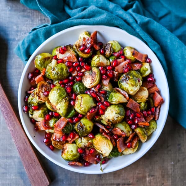 Roasted Brussels Sprouts with Bacon. These Roasted Brussels Sprouts are tossed in extra-virgin olive oil and spices and cooked until soft on the inside and crispy on the outside then drizzled with real maple syrup and served with crispy bacon and crunchy pomegranates. The perfect Fall and holiday side dish recipe.