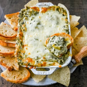 Hot Spinach Artichoke Dip. This easy spinach artichoke dip is creamy and cheesy and always a crowd pleaser! This warm spinach artichoke dip is served with tortilla chips, crackers, or bread for the perfect dip recipe.