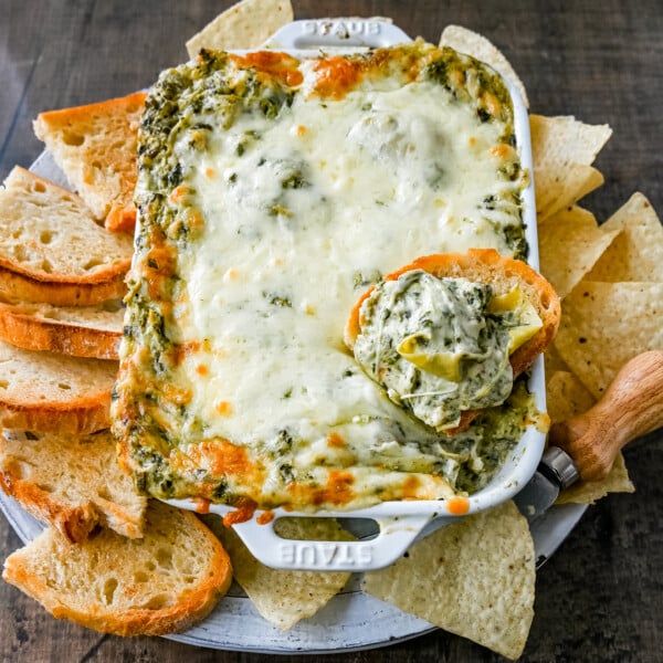 Hot Spinach Artichoke Dip. This easy spinach artichoke dip is creamy and cheesy and always a crowd pleaser! This warm spinach artichoke dip is served with tortilla chips, crackers, or bread for the perfect dip recipe.