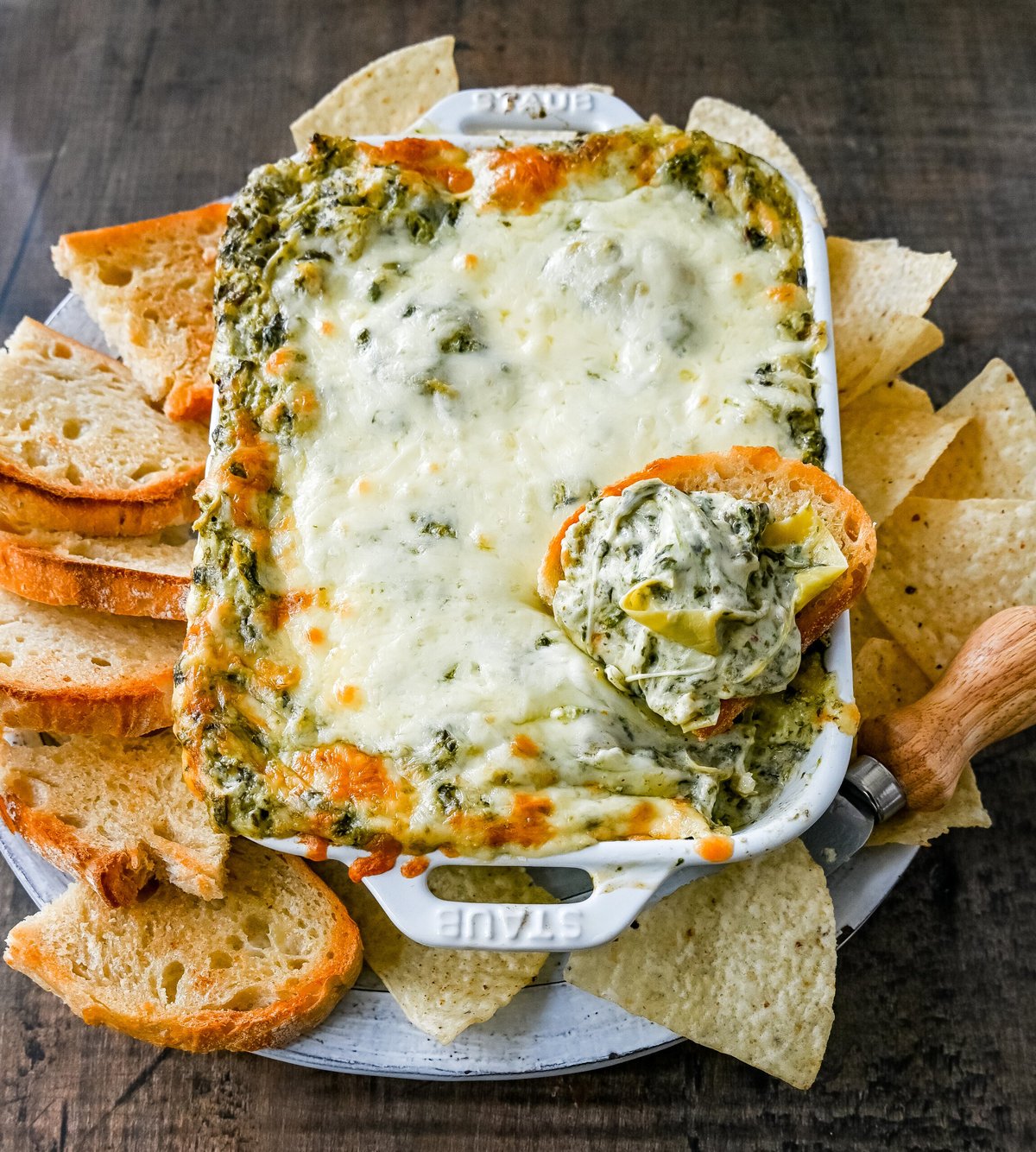 Hot Spinach Artichoke Dip. This easy spinach artichoke dip is creamy and cheesy and always a crowd pleaser! This warm spinach artichoke dip is served with tortilla chips, crackers, or bread for the perfect dip recipe.