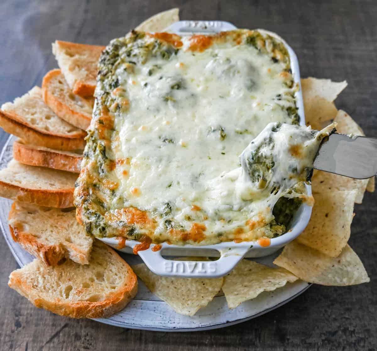 Hot Spinach Artichoke Dip. This easy spinach artichoke dip is creamy and cheesy and always a crowd pleaser! This warm spinach artichoke dip is served with tortilla chips, crackers, or bread for the perfect dip recipe.