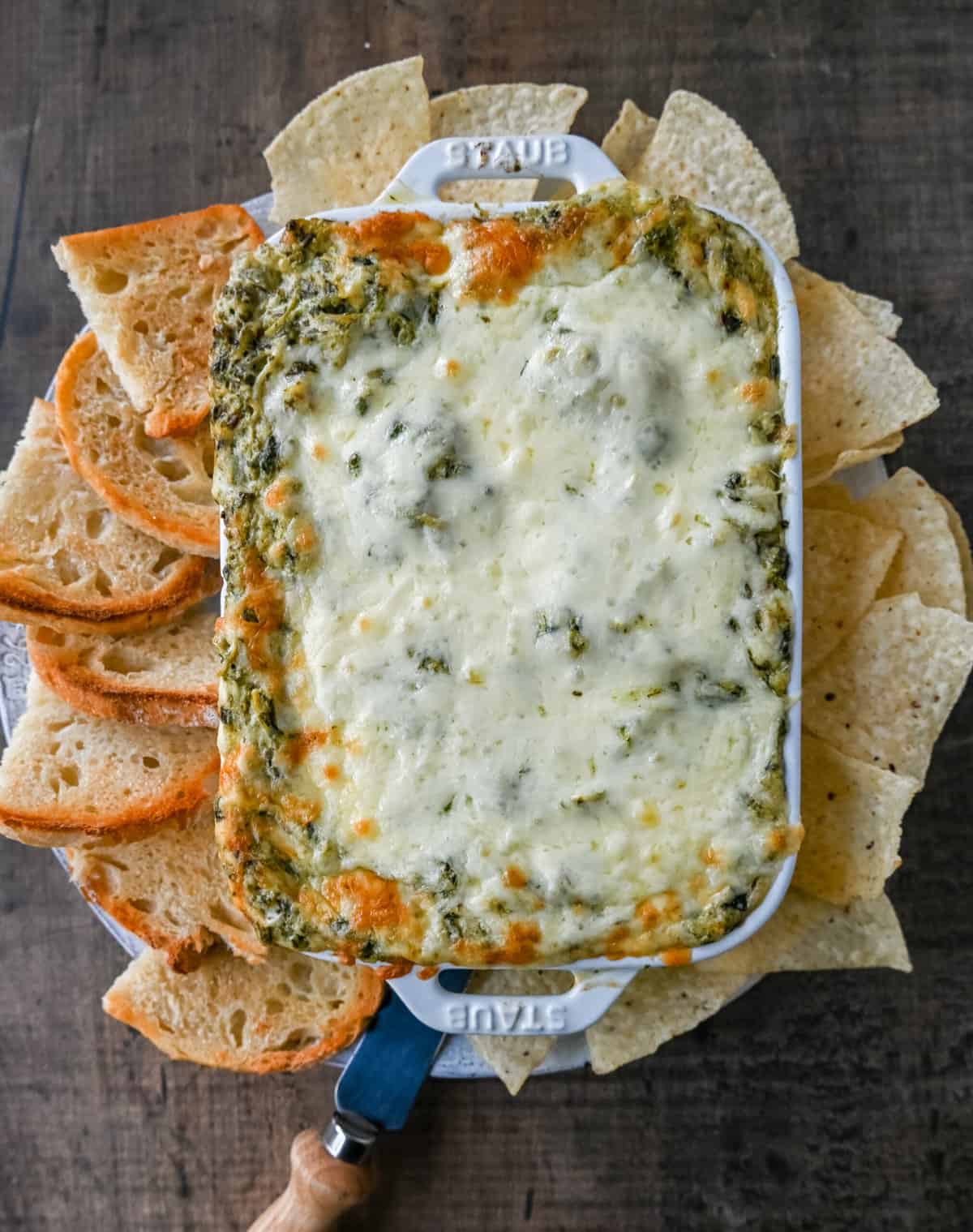 Hot Spinach Artichoke Dip. This easy spinach artichoke dip is creamy and cheesy and always a crowd pleaser! This warm spinach artichoke dip is served with tortilla chips, crackers, or bread for the perfect dip recipe.