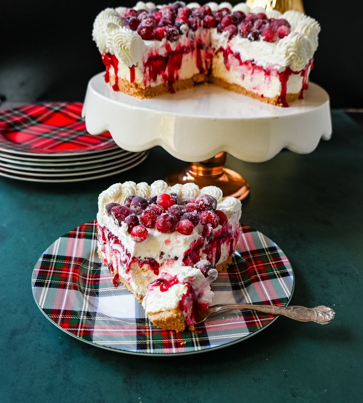 No-Bake Cranberry White Chocolate Cheesecake. This is a beautiful Christmas Cranberry Cheesecake perfect for the holidays. This no-bake white chocolate cheesecake has a graham cracker crust, white chocolate cream cheese filling, topped with homemade cranberry jam, sugared cranberries, and whipped cream.