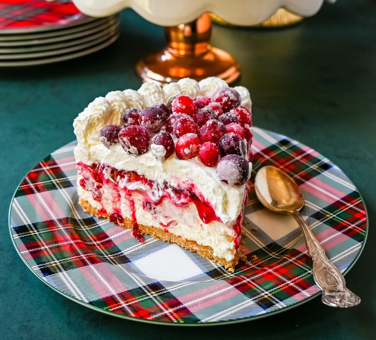 No-Bake Cranberry White Chocolate Cheesecake. This is a beautiful Christmas Cranberry Cheesecake perfect for the holidays. This no-bake white chocolate cheesecake has a graham cracker crust, white chocolate cream cheese filling, topped with homemade cranberry jam, sugared cranberries, and whipped cream.