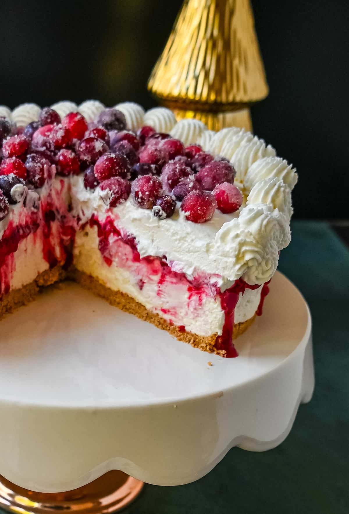 No-Bake Cranberry White Chocolate Cheesecake. This is a beautiful Christmas Cranberry Cheesecake perfect for the holidays. This no-bake white chocolate cheesecake has a graham cracker crust, white chocolate cream cheese filling, topped with homemade cranberry jam, sugared cranberries, and whipped cream.