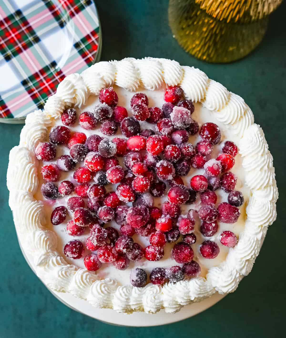 No-Bake Cranberry White Chocolate Cheesecake. This is a beautiful Christmas Cranberry Cheesecake perfect for the holidays. This no-bake white chocolate cheesecake has a graham cracker crust, white chocolate cream cheese filling, topped with homemade cranberry jam, sugared cranberries, and whipped cream.