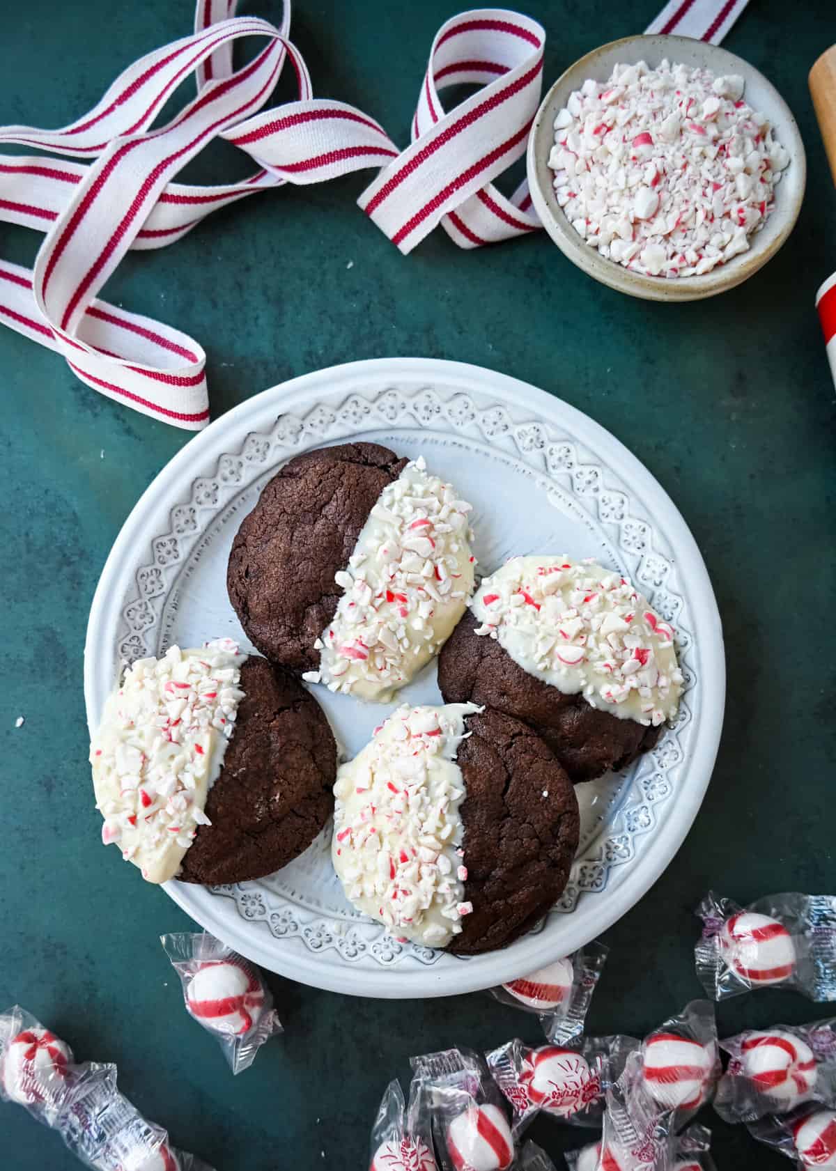 White Chocolate Dipped Peppermint Chocolate Cookies. The Double Chocolate Peppermint Cookies are soft baked, rich double chocolate brownie cookies dipped in white chocolate and covered with peppermint candy canes. The perfect Christmas holiday cookie recipe.