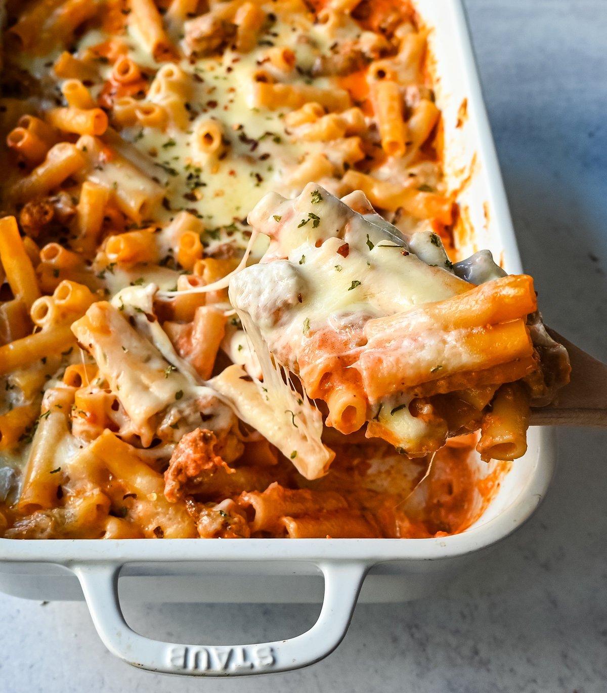 This Baked Ziti Pasta is made with ziti noodles, sausage, marinara sauce, fresh basil, spices, whole milk mozzarella cheese, parmesan cheese, and heavy cream and baked until the cheese is melted. The best-baked ziti recipe! This is a perfect recipe to freeze or make ahead of time.