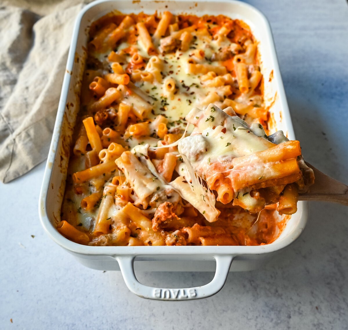 This Baked Ziti Pasta is made with ziti noodles, sausage, marinara sauce, fresh basil, spices, whole milk mozzarella cheese, parmesan cheese, and heavy cream and baked until the cheese is melted. The best-baked ziti recipe! This is a perfect recipe to freeze or make ahead of time.