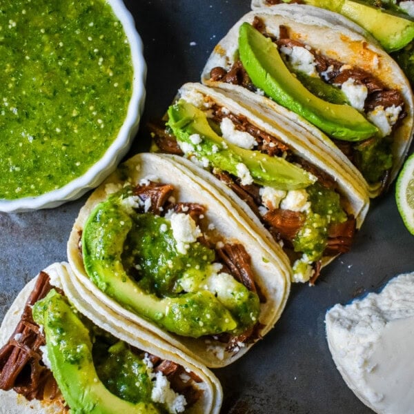 Slow Cooker Beef Barbacoa Tacos with Salsa Verde. These Barbacoa Beef Tacos with Tomatillo Salsa are made with slow cooked, Mexican spiced beef inside fresh corn tortillas and topped with homemade salsa verde, Mexican cheese, and fresh avocado. An easy and flavorful beef tacos recipe!