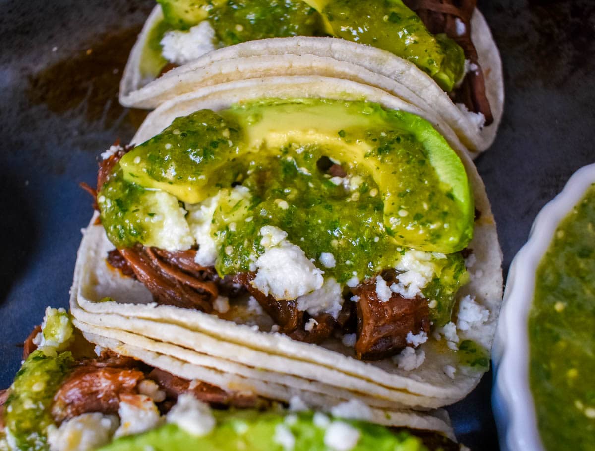 Slow Cooker Beef Barbacoa Tacos with Salsa Verde. These Barbacoa Beef Tacos with Tomatillo Salsa are made with slow cooked, Mexican spiced beef inside fresh corn tortillas and topped with homemade salsa verde, Mexican cheese, and fresh avocado. An easy and flavorful beef tacos recipe!