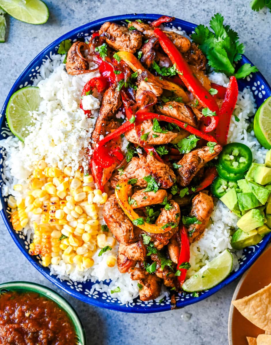 Chicken Fajita Bowl. Juicy, flavorful chicken fajitas in a bowl with rice, beans, charred corn, guacamole, salsa, and fresh cilantro. The flavors of chicken fajitas without the tortillas!