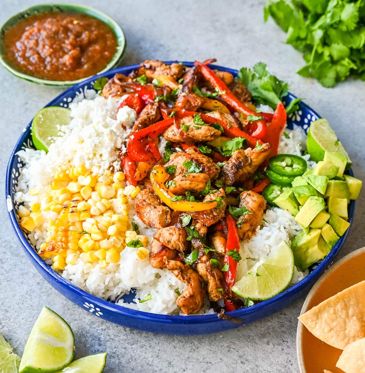 Chicken Fajita Bowl. Juicy, flavorful chicken fajitas in a bowl with rice, beans, charred corn, guacamole, salsa, and fresh cilantro. The flavors of chicken fajitas without the tortillas!