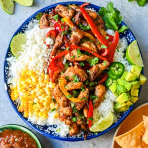 Chicken Fajita Bowl. Juicy, flavorful chicken fajitas in a bowl with rice, beans, charred corn, guacamole, salsa, and fresh cilantro. The flavors of chicken fajitas without the tortillas!