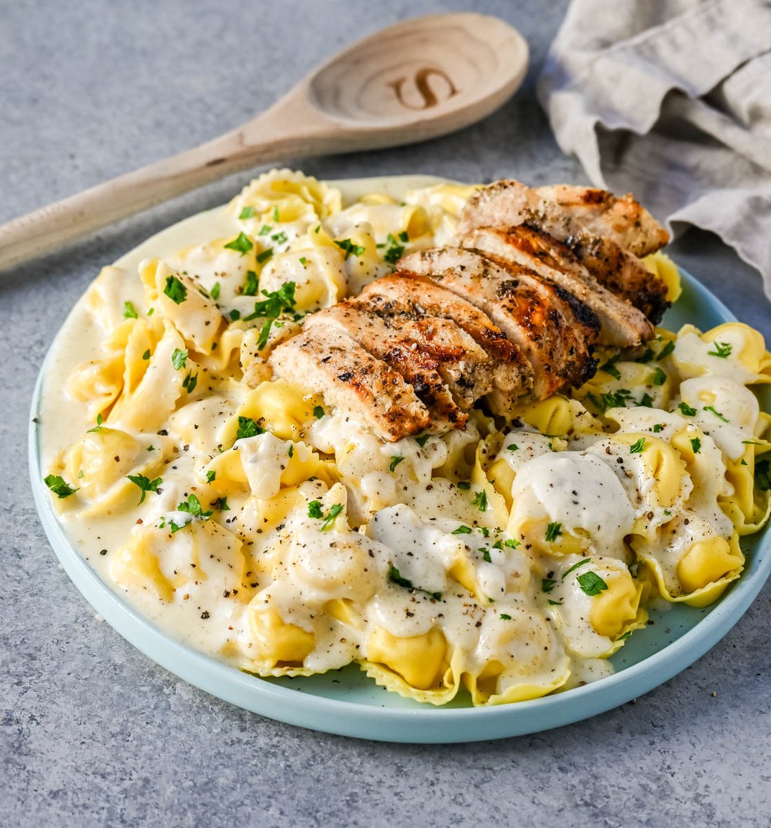 Tortellini Alfredo with Grilled Chicken is made with cheese tortellini tossed with parmesan cheese alfredo sauce and served with Italian grilled chicken. This Chicken Tortellini Alfredo Recipe is the ultimate comfort food.