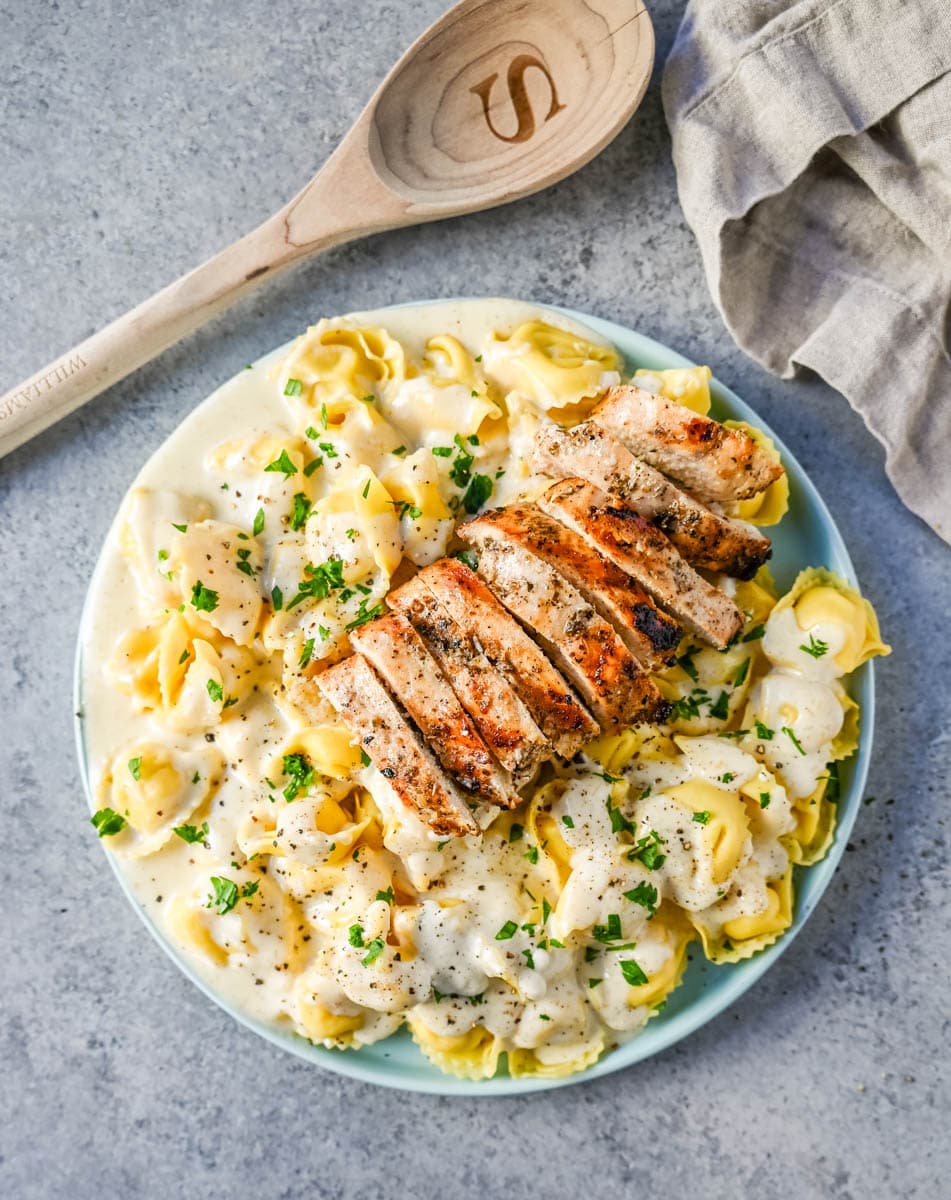 Tortellini Alfredo with Grilled Chicken is made with cheese tortellini tossed with parmesan cheese alfredo sauce and served with Italian grilled chicken. This Chicken Tortellini Alfredo Recipe is the ultimate comfort food.