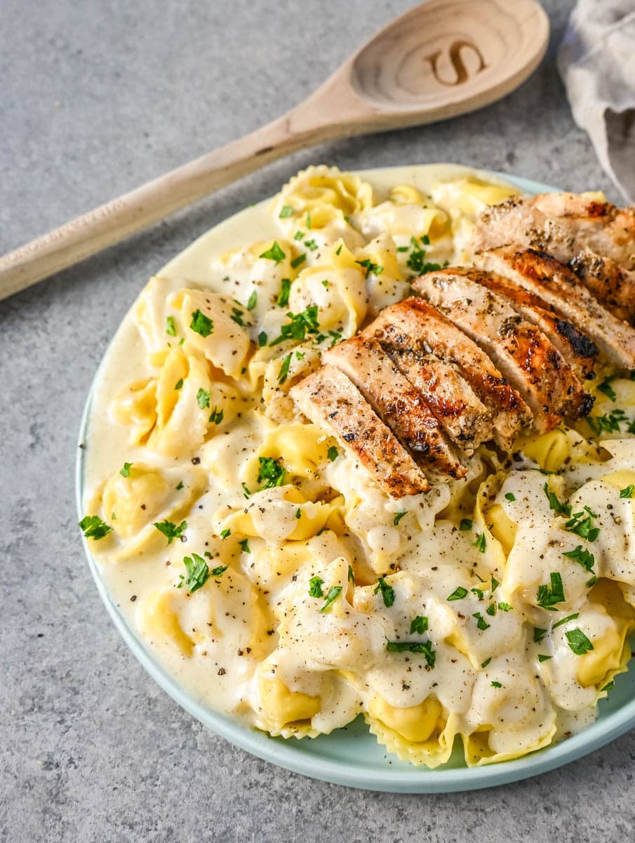 Tortellini Alfredo with Grilled Chicken is made with cheese tortellini tossed with parmesan cheese alfredo sauce and served with Italian grilled chicken. This Chicken Tortellini Alfredo Recipe is the ultimate comfort food.