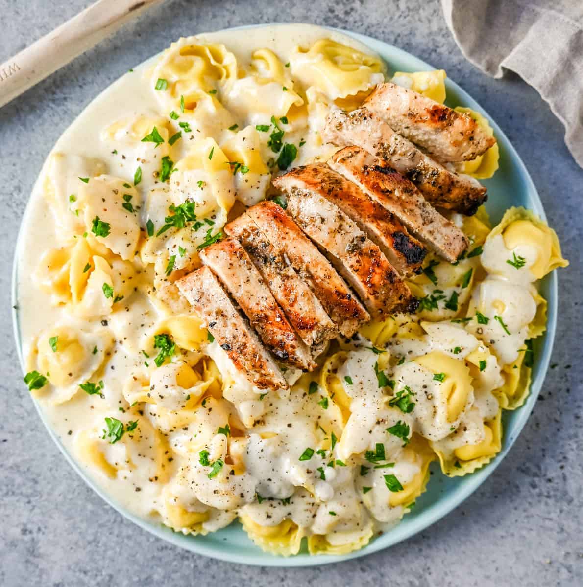 Tortellini Alfredo with Grilled Chicken is made with cheese tortellini tossed with parmesan cheese alfredo sauce and served with Italian grilled chicken. This Chicken Tortellini Alfredo Recipe is the ultimate comfort food.