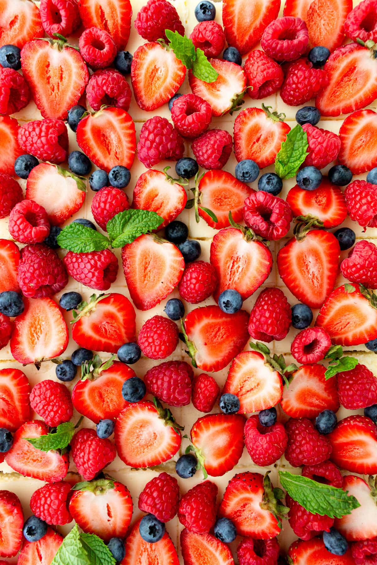 Creamy luscious cheesecake bars with a buttery graham cracker crust and topped with fresh berries is a crowd-pleasing popular dessert! They feature a creamy, tangy cheesecake filling atop a buttery graham cracker crust, baked to perfection in a bar form. Whether you're looking for a treat for a party, a family dessert, or simply craving cheesecake, these cheesecake bars are a hit.