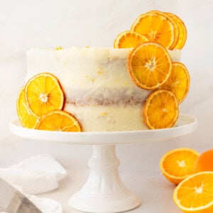 A moist, tender fresh orange cake with a sweet orange cream cheese frosting. This homemade orange cake that is bursting with bright citrus flavor in every bite. Each layer is moist, fluffy, and perfectly enhanced by an orange cream cheese frosting. The fresh orange juice and zest adds fresh orange flavor. Here are tips for making the perfect frosted orange cake! This can also be made into an orange naked cake.