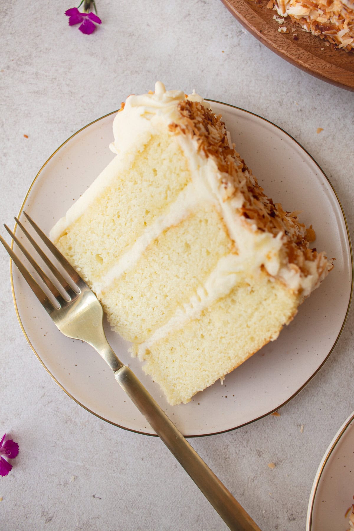This homemade, moist coconut cake with coconut cream cheese frosting is the best coconut cake recipe. It is made with sweet cream butter, coconut milk, buttermilk, coconut pudding mix, and cake flour to make it extra tender. The coconut cream cheese frosting puts it over the top!