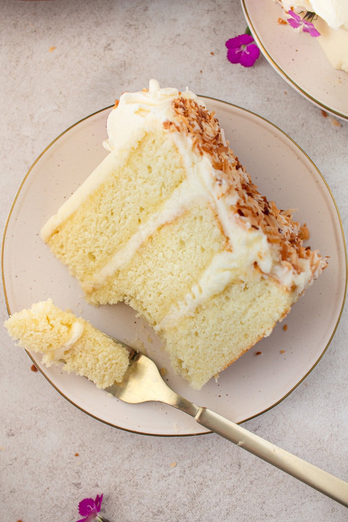 This homemade, moist coconut cake with coconut cream cheese frosting is the best coconut cake recipe. It is made with sweet cream butter, coconut milk, buttermilk, coconut pudding mix, and cake flour to make it extra tender. The coconut cream cheese frosting puts it over the top!