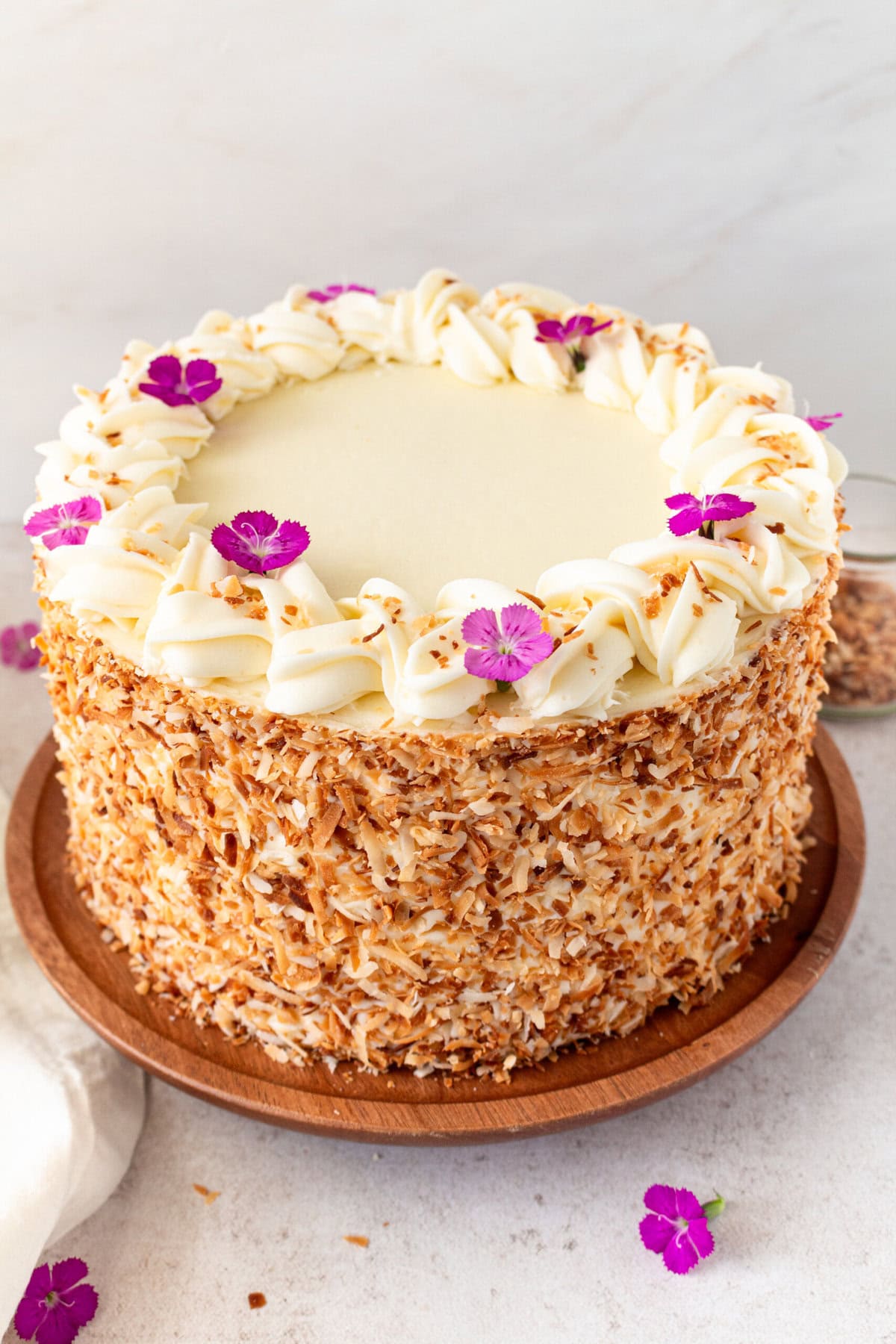 This homemade, moist coconut cake with coconut cream cheese frosting is the best coconut cake recipe. It is made with sweet cream butter, coconut milk, buttermilk, coconut pudding mix, and cake flour to make it extra tender. The coconut cream cheese frosting puts it over the top!