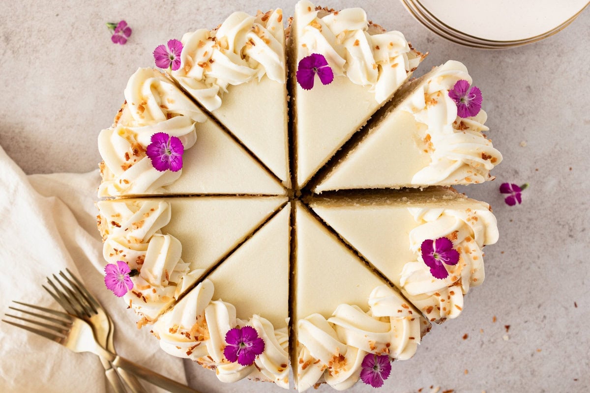 This homemade, moist coconut cake with coconut cream cheese frosting is the best coconut cake recipe. It is made with sweet cream butter, coconut milk, buttermilk, coconut pudding mix, and cake flour to make it extra tender. The coconut cream cheese frosting puts it over the top!