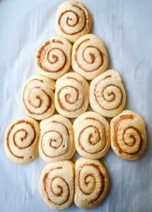 Arranging cinnamon roll dough into a Christmas tree shape to make a Cinnamon Roll Christmas Tree