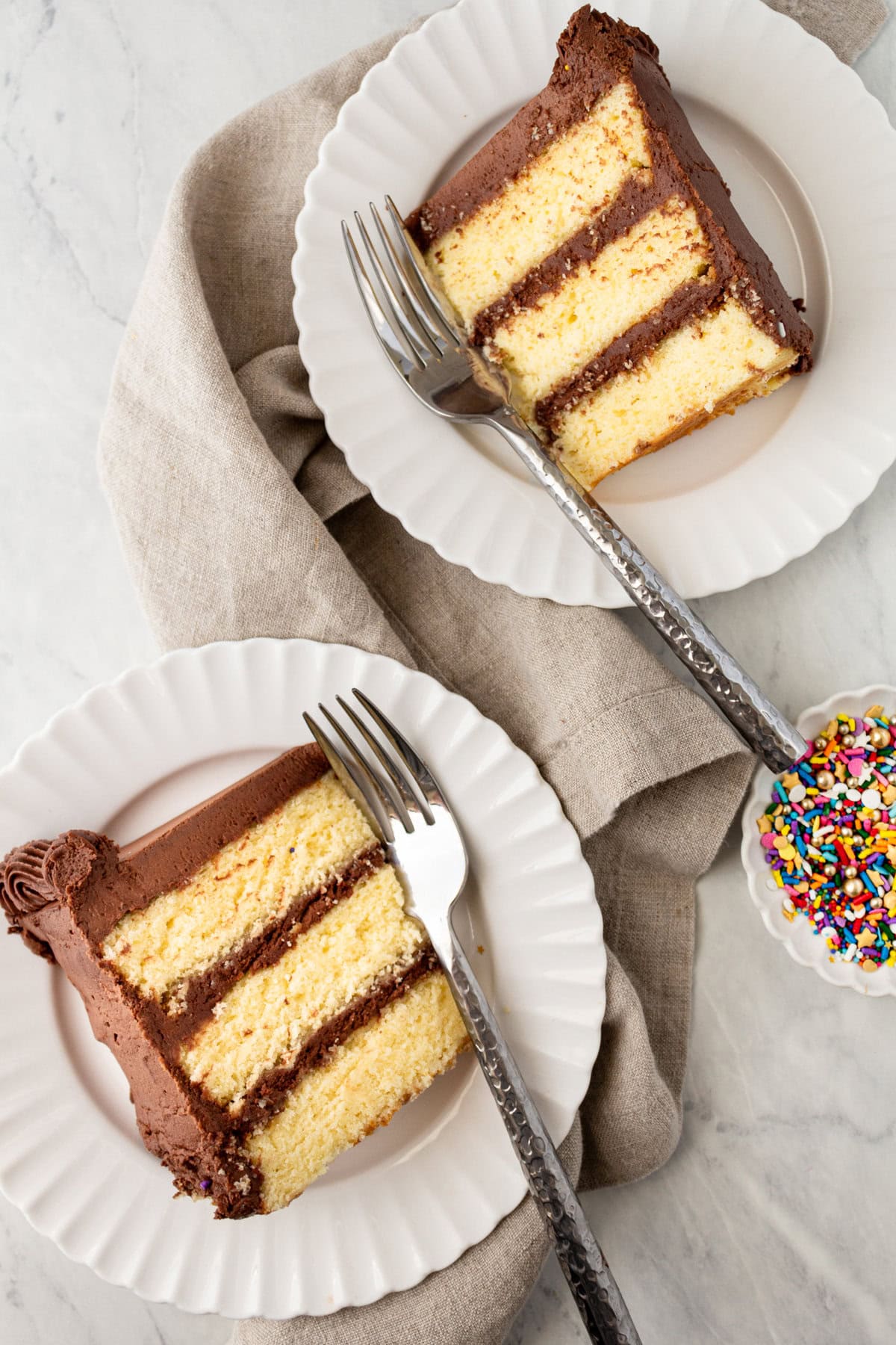 The BEST Yellow Cake Recipe with Milk Chocolate Frosting. 5-Star Rated Recipe! This golden, tender yellow cake is topped with a thick layer of creamy chocolate frosting. Thanks to a secret ingredient -- this homemade yellow cake bakes up moist, fluffy, and full of flavor every time. If you are celebrating a birthday, make sure to request this Yellow Birthday Cake with Chocolate Frosting!