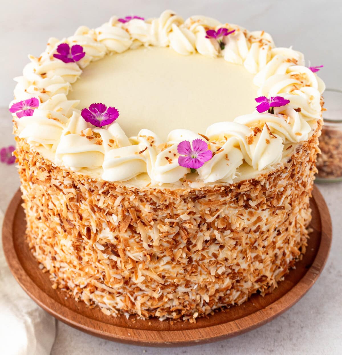 This homemade, moist coconut cake with coconut cream cheese frosting is the best coconut cake recipe. This Coconut Layer Cake is made with sweet cream butter, coconut milk, buttermilk, coconut pudding mix, and cake flour to make it extra tender. The coconut cream cheese frosting puts it over the top!