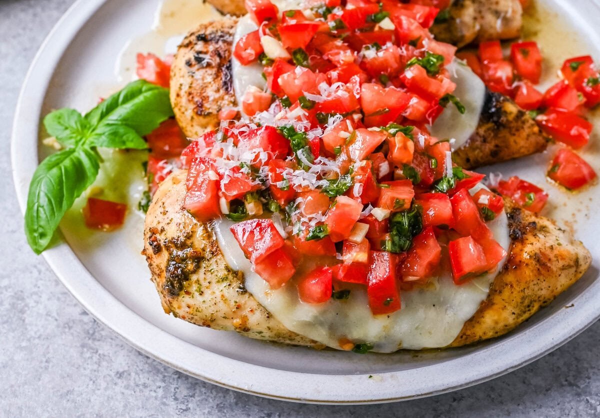 Bruschetta Grilled Chicken combines tender Italian grilled chicken breasts with juicy, garlicky tomato bruschetta, creamy melted mozzarella cheese, and a drizzle of balsamic glaze. 