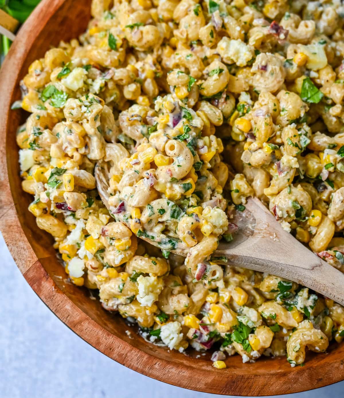 This Mexican Street Corn Pasta Salad is made with fresh corn, pasta, red onion, jalapeno, fresh cilantro, all tossed in a perfectly spiced dressing and topped with cotija cheese, Mexican spices, and fresh lime.  It’s street food meets comfort food and it is so addictive. Perfect for a summer BBQ, potluck dish, or the perfect side dish, this Mexican Street Corn Pasta Salad delivers every time.