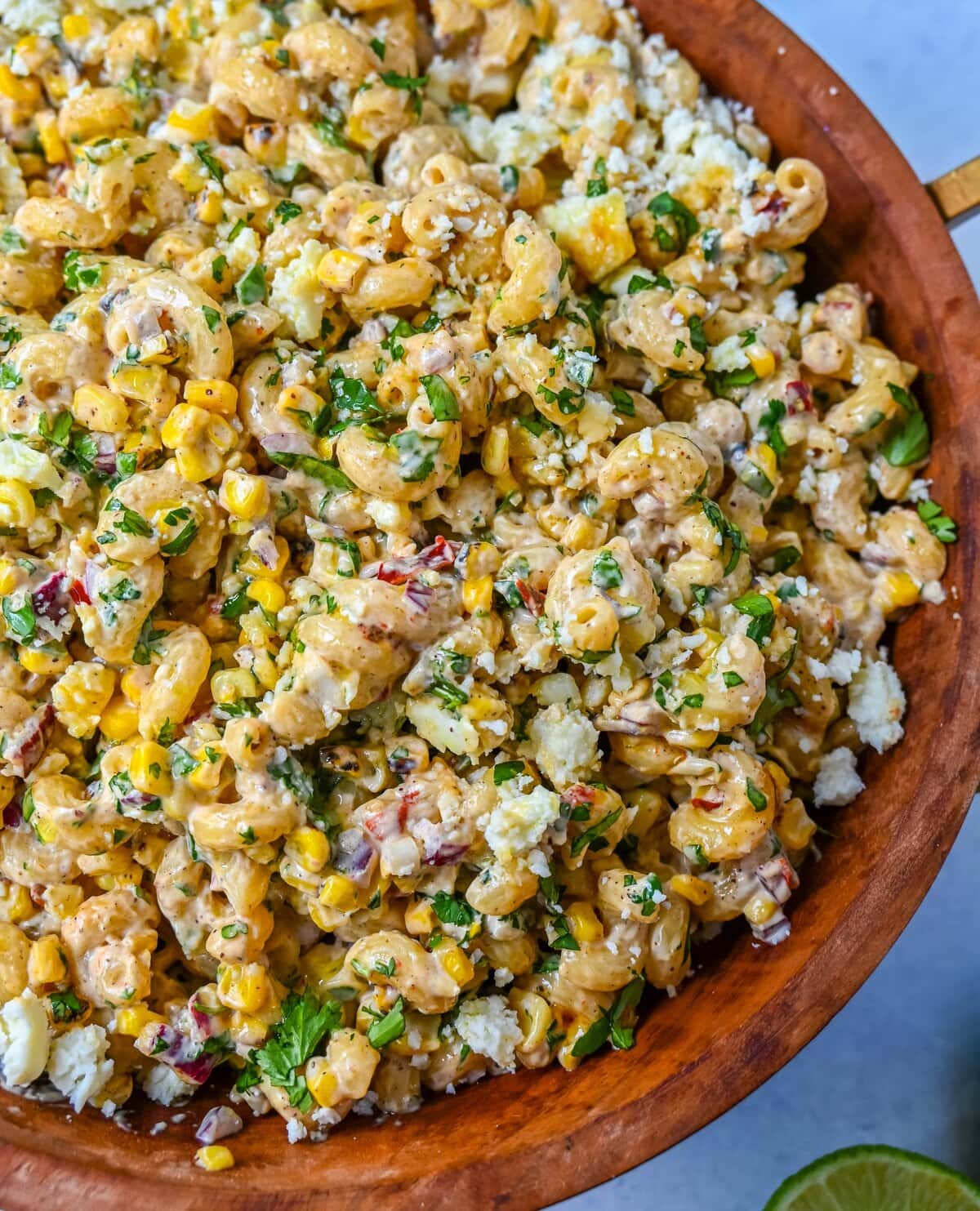 This Mexican Street Corn Pasta Salad is made with fresh corn, pasta, red onion, jalapeno, fresh cilantro, all tossed in a perfectly spiced dressing and topped with cotija cheese, Mexican spices, and fresh lime.  It’s street food meets comfort food and it is so addictive. Perfect for a summer BBQ, potluck dish, or the perfect side dish, this Mexican Street Corn Pasta Salad delivers every time.