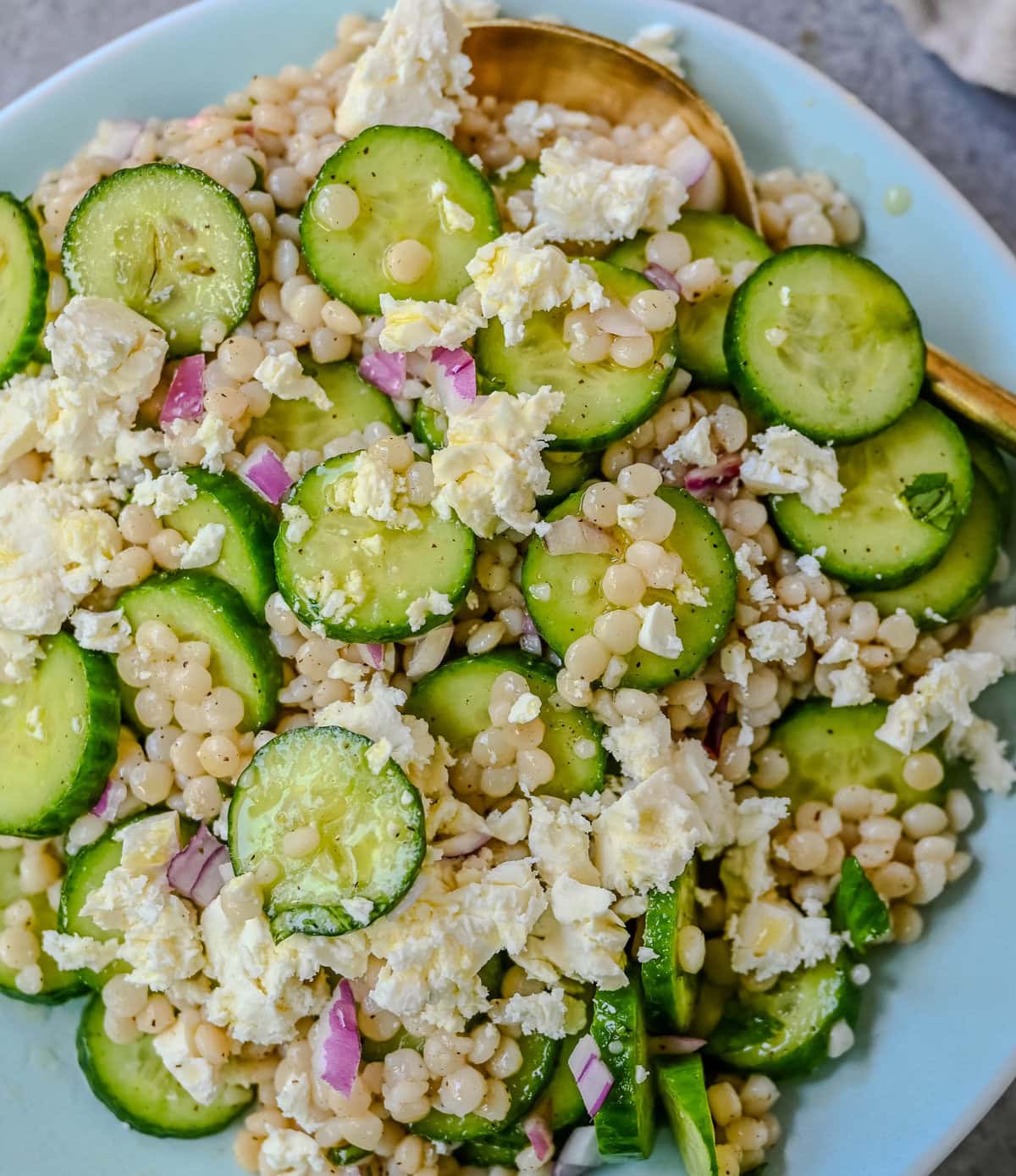 This cucumber couscous salad is the ultimate fresh and easy Mediterranean inspired recipe that is light, flavorful, and ready in just 20 minutes. Fluffy couscous is tossed with crisp English cucumber, red onion, and creamy feta cheese then drizzled with a bright and tangy lemon vinaigrette that makes the best fresh side dish!