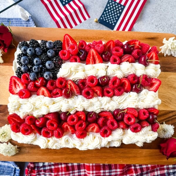 Best Flag Cake Recipe. Looking for a show-stopping, patriotic dessert that’s as delicious as it is beautiful? This American Flag Cake is your go-to recipe! It starts with a moist vanilla cake base, is topped with a lusciously light whipped cream cheese frosting, and decorated with fresh berries and cherries arranged like the U.S. flag.