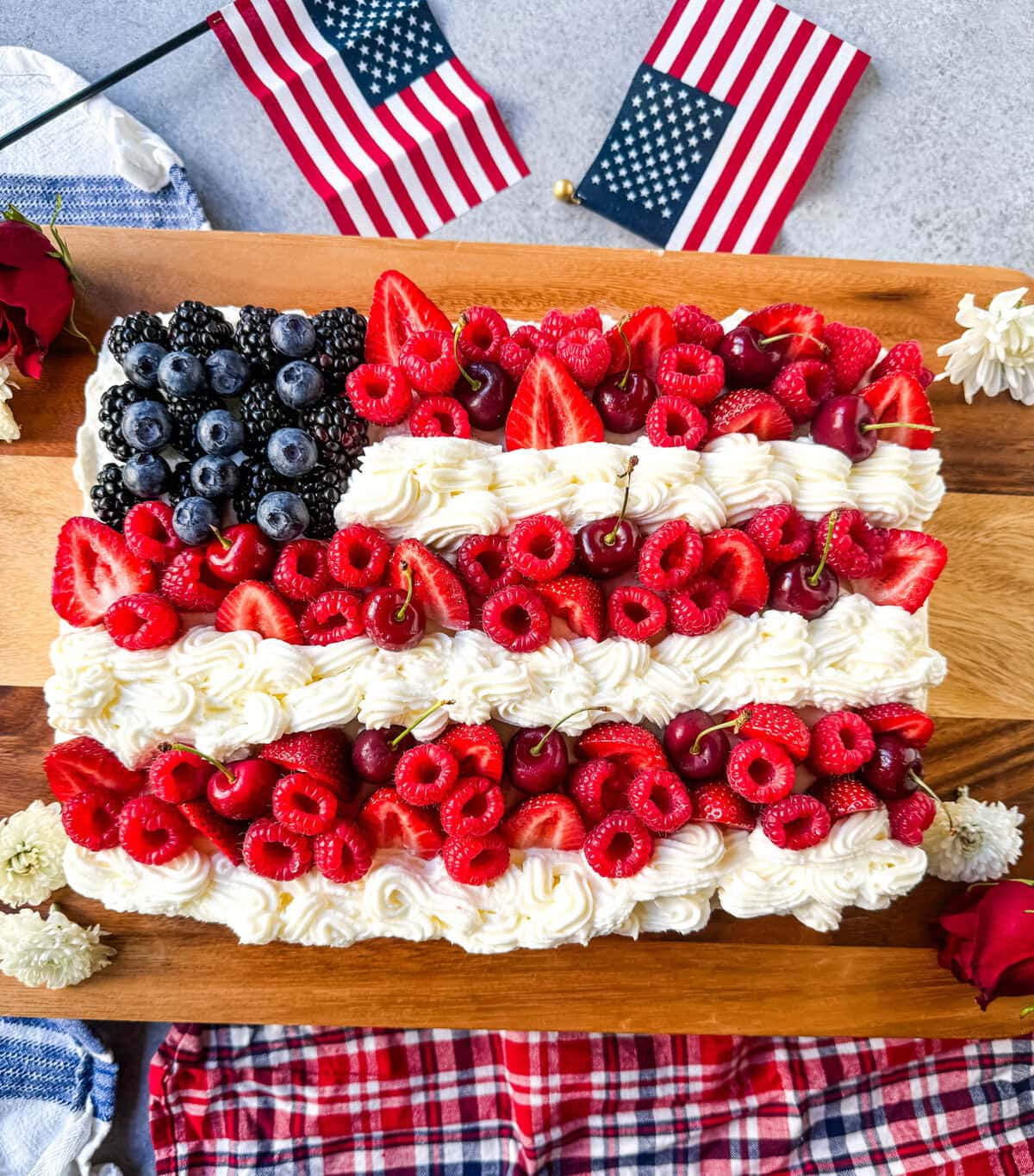 Best Flag Cake Recipe. Looking for a show-stopping, patriotic dessert that’s as delicious as it is beautiful? This American Flag Cake is your go-to recipe! It starts with a moist vanilla cake base, is topped with a lusciously light whipped cream cheese frosting, and decorated with fresh berries and cherries arranged like the U.S. flag.