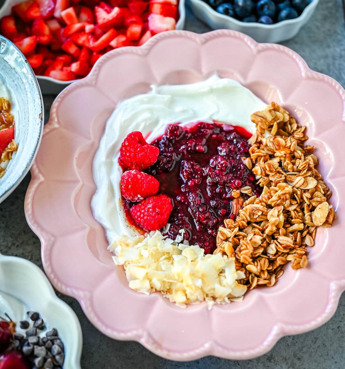 Greek Yogurt Breakfast Bowl with Raspberry Chia Jam. Greek Yogurt, raspberry chia jam, raspberries, granola, coconut flakes.