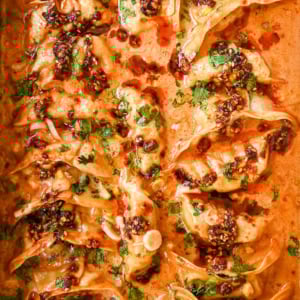 These viral baked dumplings from TikTok are the ultimate easy dinner hack! Crispy dumplings are baked in a creamy coconut curry sauce and topped with cilantro, chili crunch oil, and sesame seeds for the perfect mix of flavor and texture. This is an easy sheet pan dinner recipe!