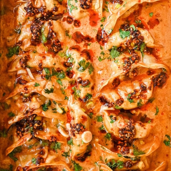 These viral baked dumplings from TikTok are the ultimate easy dinner hack! Crispy dumplings are baked in a creamy coconut curry sauce and topped with cilantro, chili crunch oil, and sesame seeds for the perfect mix of flavor and texture. This is an easy sheet pan dinner recipe!